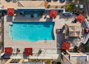 Thumbnail 9 of 12 - An aerial view of a pool surrounded by red umbrellas and chairs.