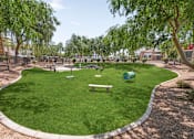 Thumbnail 10 of 12 - A park with a green lawn and a bench.