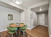 Thumbnail 17 of 42 - A dining room with a round table and green chairs.