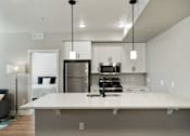 Thumbnail 2 of 42 - a kitchen with a large island and a stainless steel refrigerator