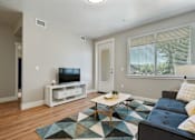 Thumbnail 12 of 42 - A living room with a blue couch and a television.