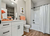 Thumbnail 19 of 42 - A white bathroom with a toilet, sink, and shower.