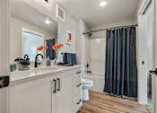 Thumbnail 29 of 42 - A bathroom with a white countertop and a toilet with a black handle.