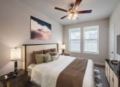 Thumbnail 6 of 31 - a bedroom with a large bed and a ceiling fan