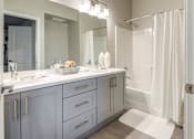 Thumbnail 18 of 18 - A bathroom with a white shower curtain and a white sink.