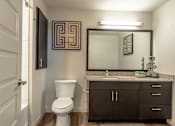 Thumbnail 7 of 26 - A bathroom with a toilet, sink, and mirror.