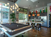 Thumbnail 10 of 26 - A pool table is in the middle of a room with a bar and a dining table.