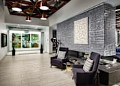 Thumbnail 12 of 15 - A modern living room with a grey sofa and a grey armchair.