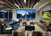 Thumbnail 9 of 15 - A modern living room with a large window overlooking a street.