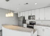 Thumbnail 8 of 32 - a kitchen with white cabinets and granite counter tops
