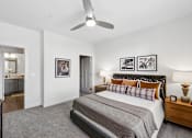 Thumbnail 24 of 28 - A bedroom with a large bed and a ceiling fan.