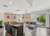 Thumbnail 1 of 32 - a living room with a kitchen and a sliding glass door