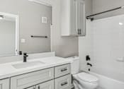 Thumbnail 17 of 33 - A white bathroom with a sink, toilet, and bathtub.