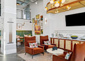 Thumbnail 13 of 28 - A living room with a white column and a green couch.