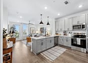 Thumbnail 18 of 28 - A modern kitchen with a large island and stainless steel appliances.