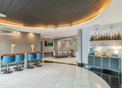 Thumbnail 4 of 32 - a bar with blue chairs and a table in a lobby