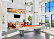 Thumbnail 10 of 28 - A billiard table is in the middle of a room with a television and a couch.