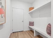 Thumbnail 8 of 17 - A white door is in a room with a bench and a shelf.