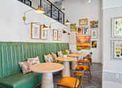 Thumbnail 14 of 28 - A restaurant with green booths and wooden tables.
