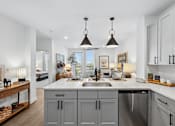 Thumbnail 19 of 28 - A kitchen with a large island and a sink.