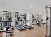 Thumbnail 17 of 28 - A gym with treadmills, weights and exercise machines.