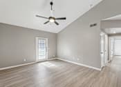 Thumbnail 20 of 33 - A room with a ceiling fan and wooden flooring.