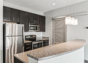 Thumbnail 9 of 32 - a kitchen with granite counter tops and stainless steel appliances