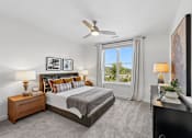 Thumbnail 23 of 28 - A bedroom with a large bed, a ceiling fan, and a view of the outdoors through a window.