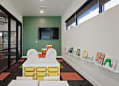 Thumbnail 25 of 35 - A room with a green wall and a white shelf with books on it.