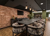 Thumbnail 46 of 68 - A room with a long table and chairs with a brick wall on one side.