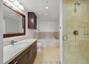 Thumbnail 30 of 41 - A bathroom with a sink, mirror, toilet, and shower.