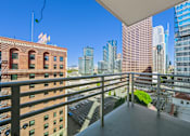 Thumbnail 25 of 41 - A balcony overlooks a cityscape with a mix of modern and older buildings.