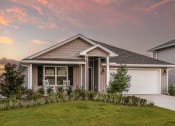 Thumbnail 4 of 40 - a home with a gray roof and a pink sunset in the background