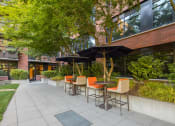 Thumbnail 29 of 44 - Patio with tables and chairs and umbrellas in front of a building at The Wyatt, Portland