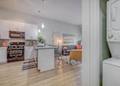 Thumbnail 2 of 24 - A modern kitchen with white appliances and wooden floors.
