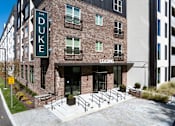 Thumbnail 27 of 27 - The Duke building is a brick apartment complex with a leasing office.