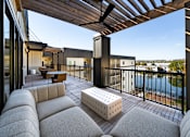 Thumbnail 13 of 27 - A modern balcony with a white couch and a wooden pergola.