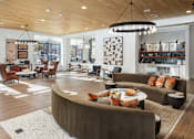 Thumbnail 8 of 27 - A modern living room with a curved sofa and a chandelier.