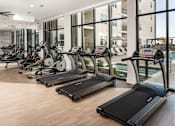 Thumbnail 19 of 27 - A gym with treadmills and exercise bikes.