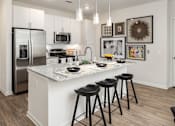 Thumbnail 1 of 27 - A kitchen with a white island and black stools.