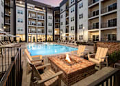Thumbnail 3 of 27 - A fire pit sits in the middle of a patio surrounded by chairs.