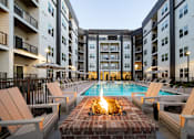 Thumbnail 4 of 27 - A pool surrounded by lounge chairs and umbrellas in a courtyard.