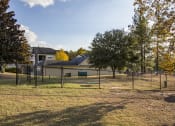 Thumbnail 8 of 13 - Fenced in dog park with a building in the background