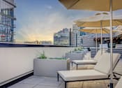 Thumbnail 13 of 30 - a terrace with chairs and umbrellas and a view of the city