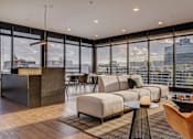Thumbnail 9 of 30 - a living room with a city view and a couch and a table