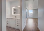 Thumbnail 26 of 30 - White finished bathroom leading into hallway with wood flooring