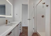 Thumbnail 25 of 30 - bathroom with fully lit mirror, standing shower and spacious countertops