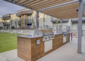 Thumbnail 11 of 26 - A patio with a barbecue grill and a table with chairs
