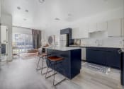 Thumbnail 1 of 26 - a kitchen with a blue island and stools in front of a living room
