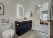Thumbnail 7 of 26 - a bathroom with a toilet and a sink and a mirror